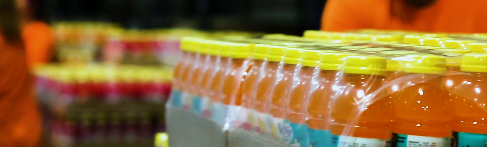 Orange drink bottles shrink wrapped in a carton